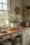 Cozy small farmhouse kitchen with a butcher block countertop, white shiplap walls, and a rustic bread loaf on a wooden cutting board.